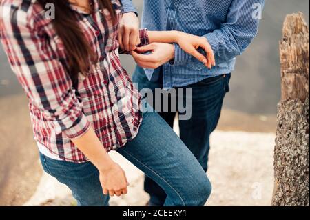 Crop legs of two men in jeans standing on concrete block at the water. Stock Photo