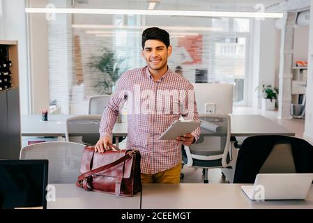 Smiling man with tablet in office Stock Photo