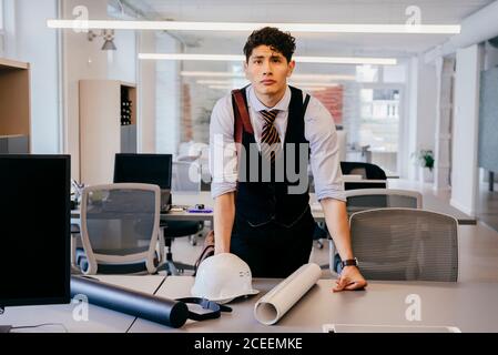 Young man with blueprint in office Stock Photo