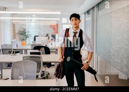 Young man with blueprint in office Stock Photo