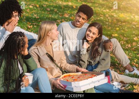 Group of teenagers having picnic at public park Stock Photo