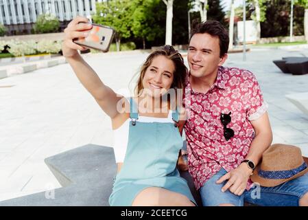 Couple taking selfie on bench Stock Photo