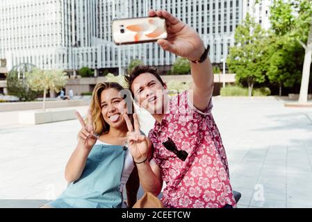 Couple taking selfie on bench Stock Photo