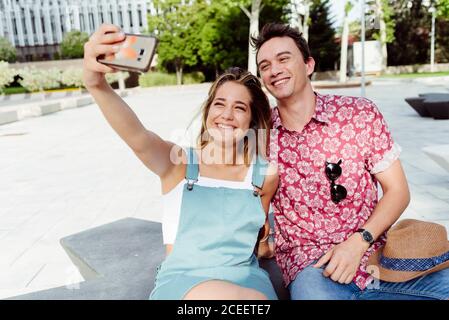 Couple taking selfie on bench Stock Photo