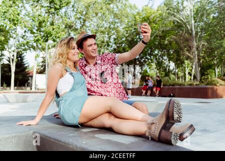 Couple taking selfie on bench Stock Photo