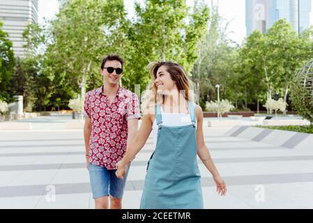 Couple holding hands and walking on street Stock Photo