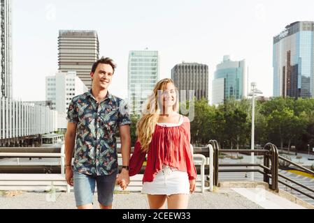 Couple holding hands and walking on street Stock Photo
