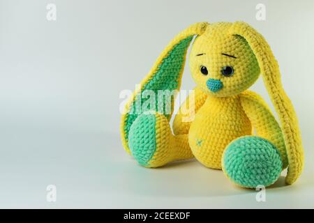 A plush yellow hare on a white background with a copy of the space. Children's toy. There is space for text Stock Photo