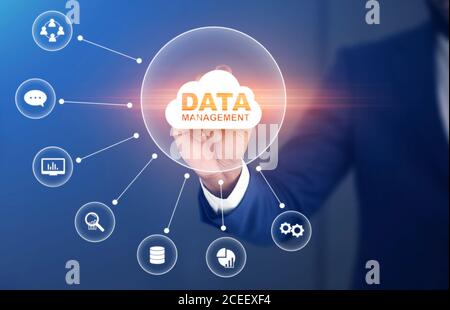 Data Management System, DMS. Businessman pressing data storage cloud on virtual screen Stock Photo
