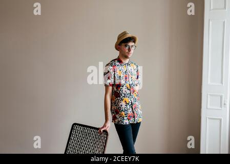 Young handsome stylish man leaning on chair and posing at home. Stock Photo