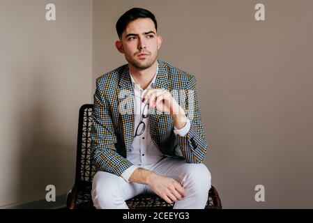 Thoughtful stylish young man on chair Stock Photo