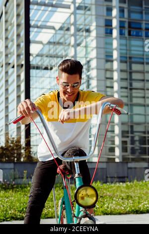Attractive young man sitting on vintage bicycle Stock Photo