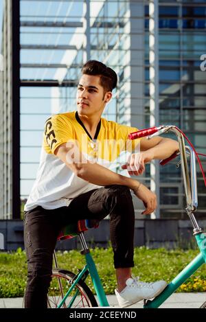 Attractive young man sitting on vintage bicycle Stock Photo