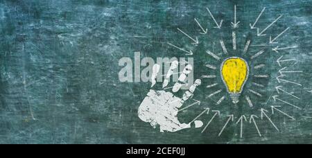 Idea, innovation, solutuion concept weth light bulb and human hand on black board, design template, large copy space Stock Photo