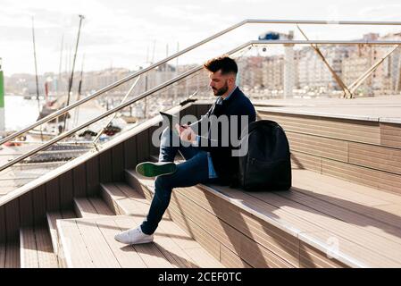 Stylish man using tablet in port Stock Photo