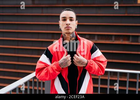 Young man with tattoos standing on street Stock Photo