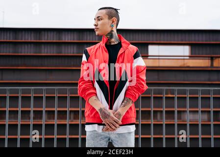 Young man with tattoos standing on street Stock Photo