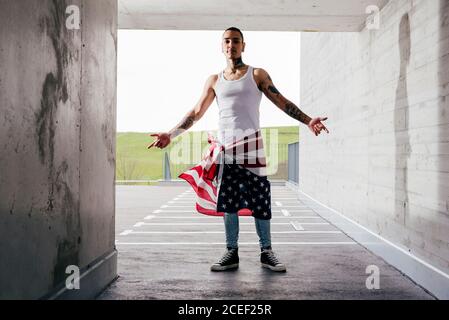 Hispanic man with tattooed hands wearing casual clothes standing showing steepness in underground parking Stock Photo