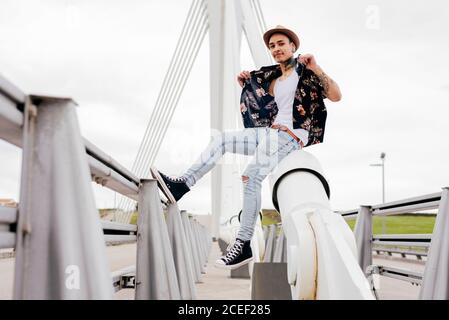 Handsome man with tattooed hands wearing casual clothes and smiling at camera Stock Photo