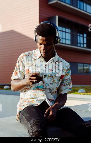 Black man in headphones using smartphone Stock Photo
