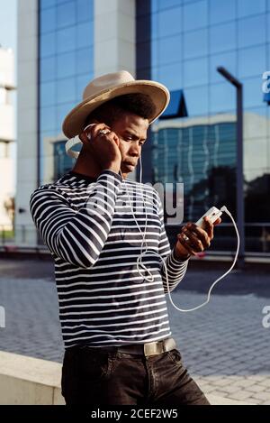 Black man in headphones using smartphone Stock Photo