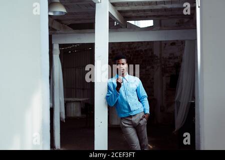 Stylish black man leaning on wall Stock Photo