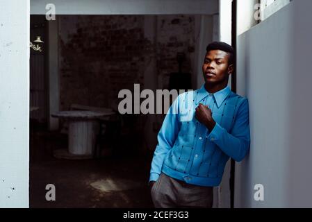Stylish black man leaning on wall Stock Photo
