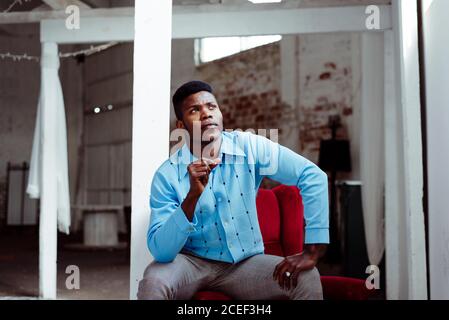 Elegant African-American man sitting on arm pad Stock Photo