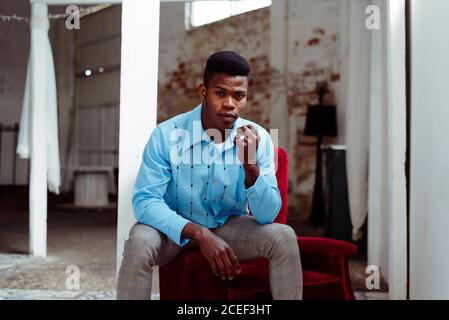 Elegant African-American man sitting on arm pad Stock Photo