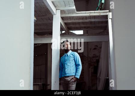 Stylish black man leaning on wall Stock Photo
