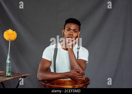 Stylish black man sitting near table Stock Photo