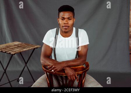 Stylish black man sitting near table Stock Photo