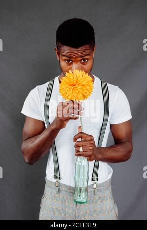 Stylish black man smelling flower Stock Photo