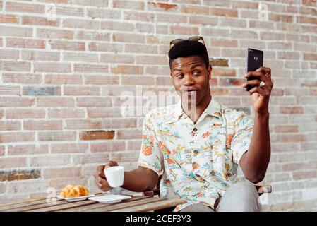 man using smartphone during breakfast Stock Photo