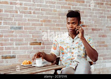 man using smartphone during breakfast Stock Photo