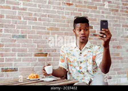man using smartphone during breakfast Stock Photo