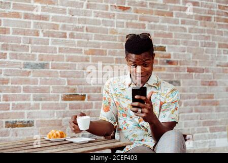 man using smartphone during breakfast Stock Photo