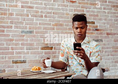 man using smartphone during breakfast Stock Photo
