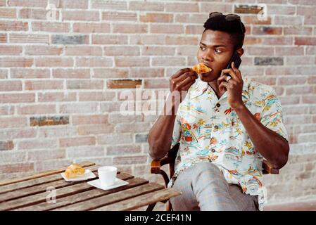 man using smartphone during breakfast Stock Photo