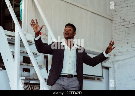 Black man standing on ladder Stock Photo
