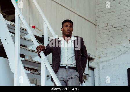 Black man standing on ladder Stock Photo