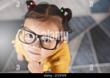 Cute little asian girl with thinking gesture looking at camera. Concept of child education Stock Photo