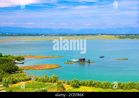 Aerial view of Torcello islands, traditional fishing station house with fishnet in water of Venetian Lagoon. Panoramic view from bell tower. Veneto Region, Northern Italy. Blue cloudy sky background. Stock Photo