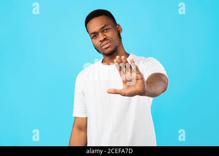 Serious Black Guy Gesturing Stop Standing Over Blue Background Stock Photo
