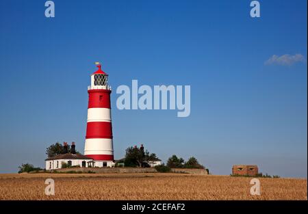 A view of the independently operated lighthouse with hexagonal pill box on the North Norfolk coast at Happisburgh, Norfolk, England, United Kingdom. Stock Photo