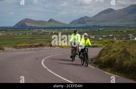 Dingle Peninsula, Ireland - 29th August 2020: Tourists cycling scenic Slea Head Drive on the Dingle peninsula, county Kerry on the west coast of the R Stock Photo
