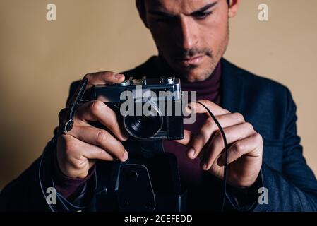 Young man in a studio holding a vintage camera Stock Photo