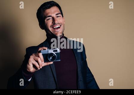 Young man in a studio holding a vintage camera Stock Photo
