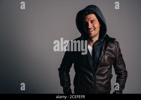 Young attractive brunet man wearing a hoodie in a studio Stock Photo
