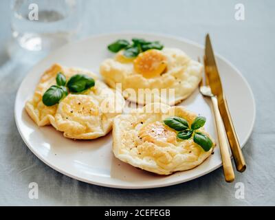 Fluffy Cloud Eggs. Trendy food - oven bake scrambled eggs with whipped egg white and whole yolk on plate Stock Photo